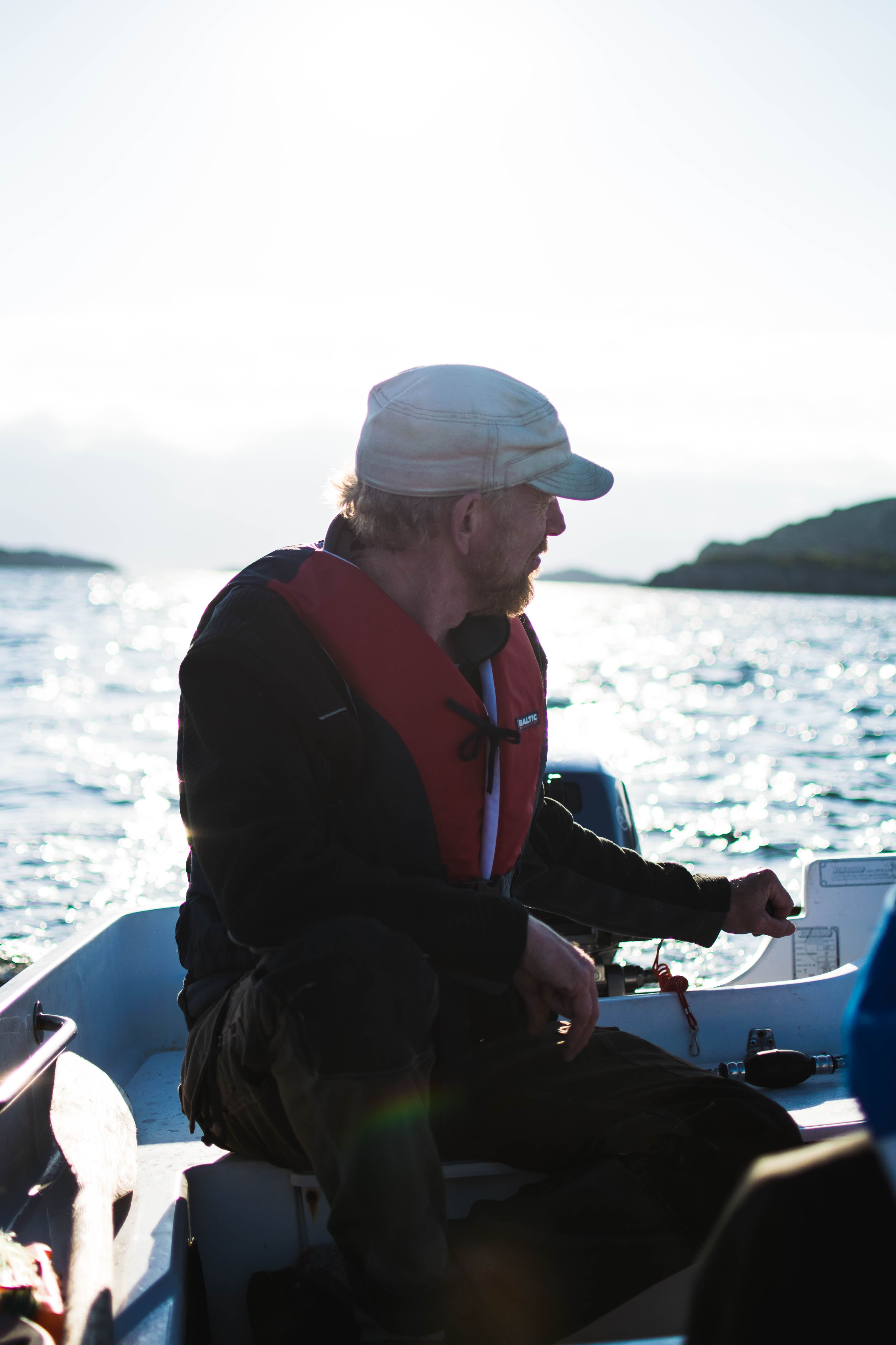 Mann kjører båt med påhengsmotor