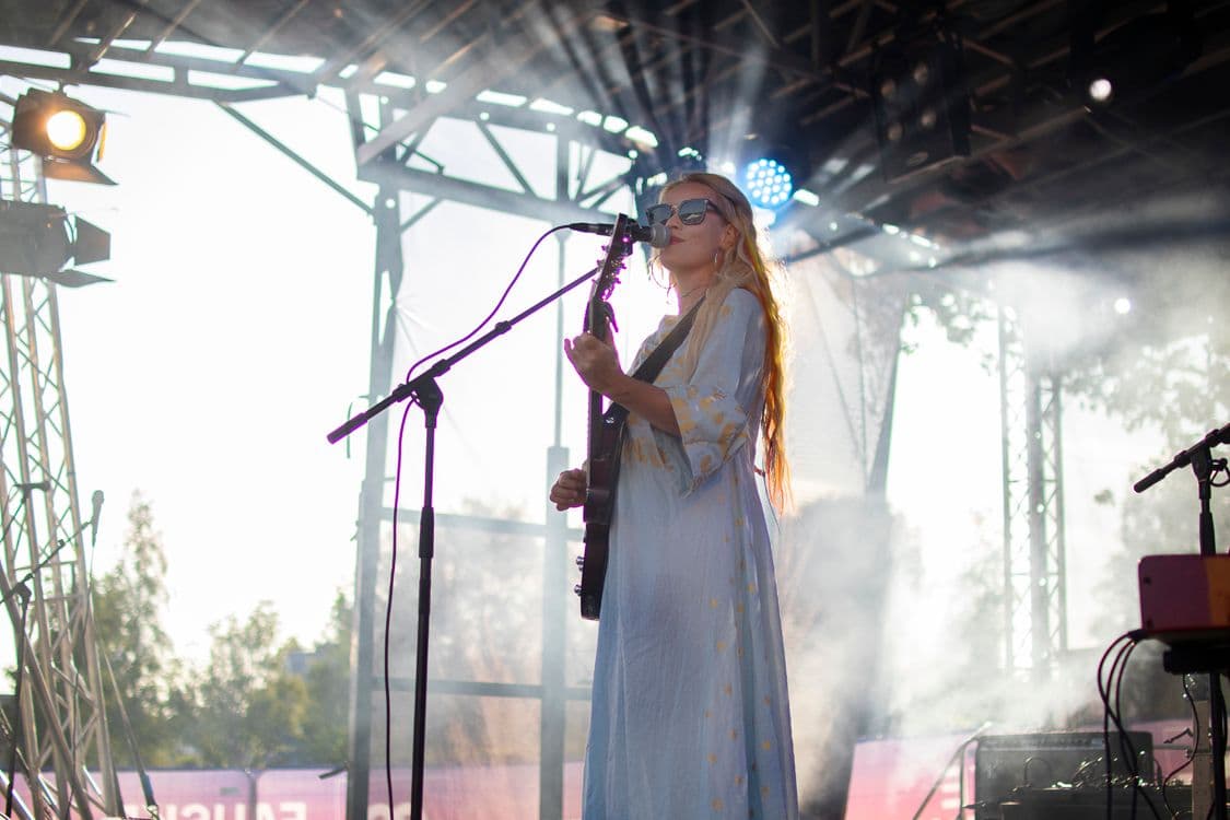 Unni Wilhelmsen med gitar på en utescene