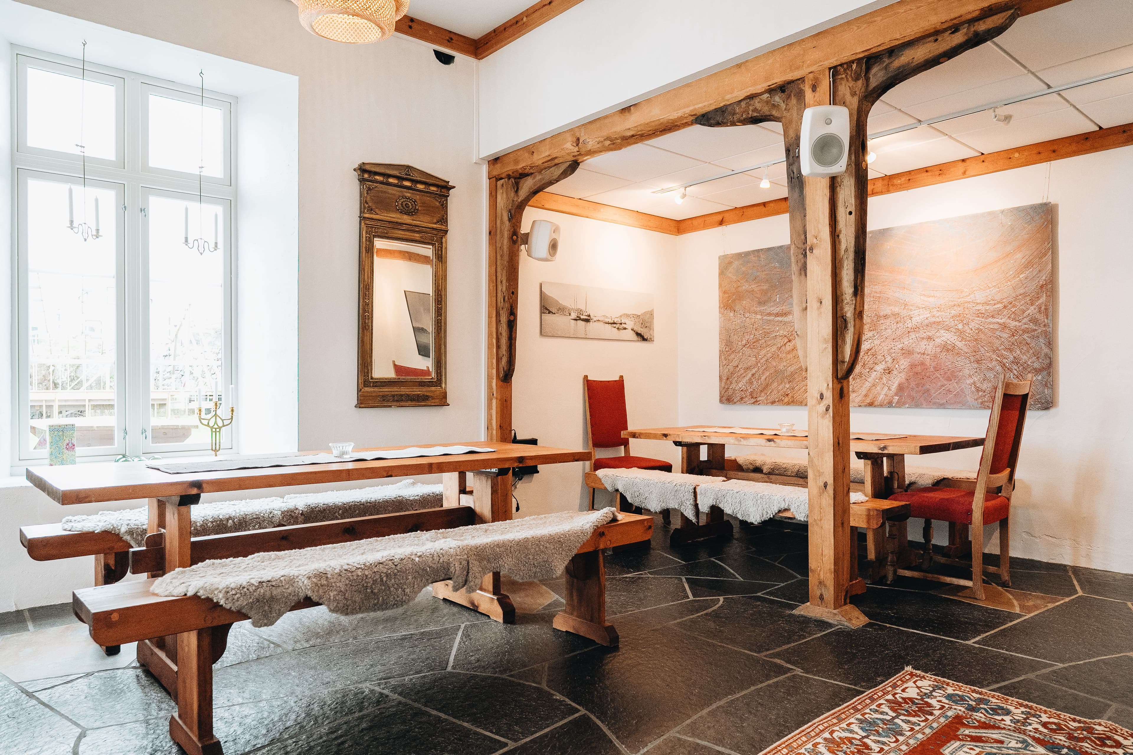 Varmt selskapslokale med tre store bord og benker